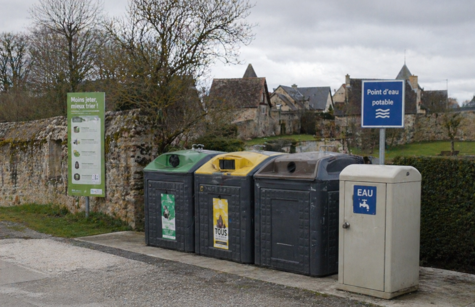 Des conteneurs de tri et un point d'"eau dans une rur